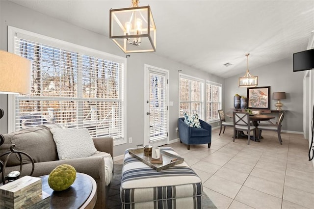 living area featuring lofted ceiling, baseboards, an inviting chandelier, and light tile patterned floors