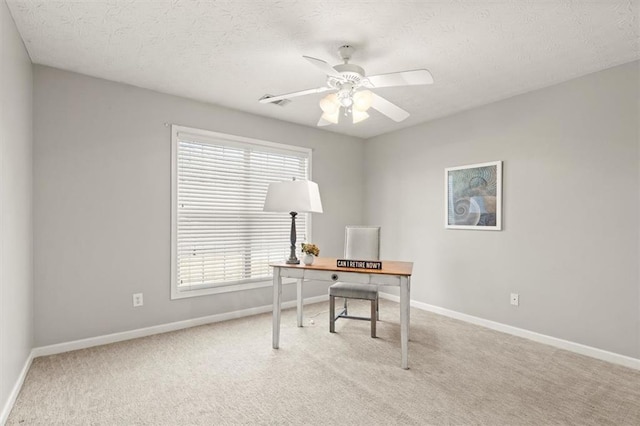 office area featuring light colored carpet, ceiling fan, a textured ceiling, and baseboards