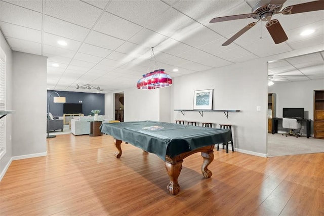 recreation room featuring light wood-style floors, baseboards, a drop ceiling, and recessed lighting