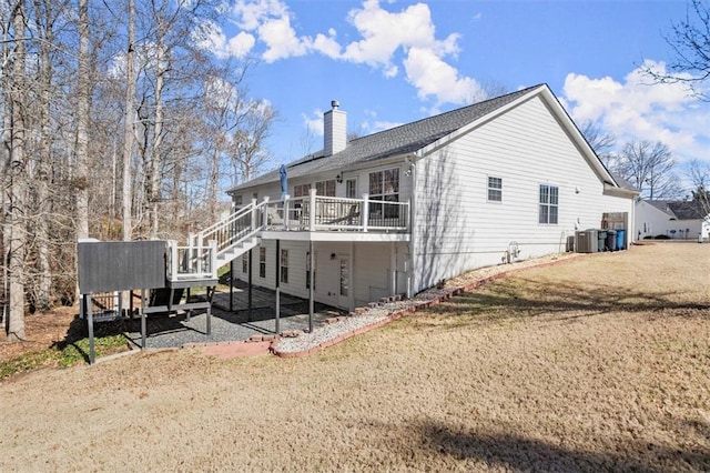 view of side of home with a deck, cooling unit, a yard, and a chimney