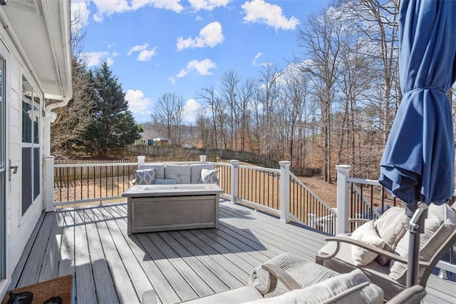 wooden terrace with an outdoor living space with a fire pit