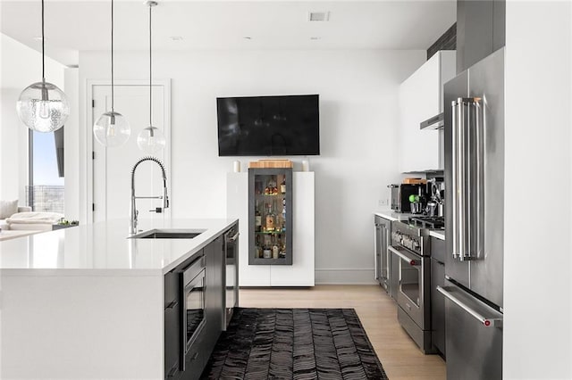 788 W Marietta St Unit 1809, Atlanta, GA 30318 - kitchen featuring premium appliances, a sink, light countertops, light wood finished floors, and modern cabinets