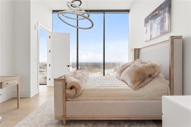 788 W Marietta St Unit 1809, Atlanta, GA 30318 - bedroom featuring a wall of windows, wood finished floors, multiple windows, and a chandelier