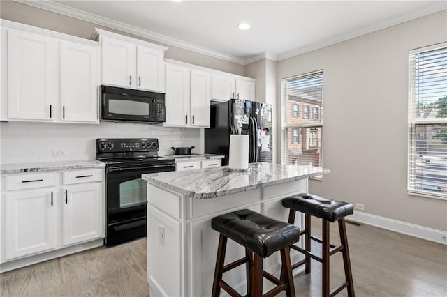 286 Blue Pointe Ct, Suwanee, GA 30024 - kitchen with black appliances, a kitchen breakfast bar, a center island, white cabinetry, and tasteful backsplash