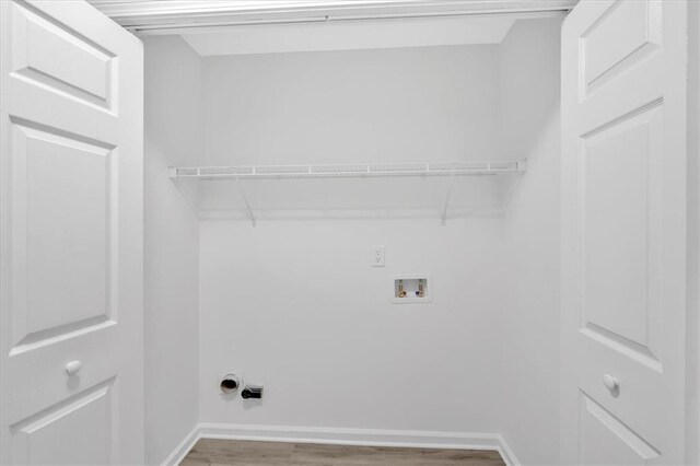 laundry room featuring laundry area, washer hookup, baseboards, and wood finished floors