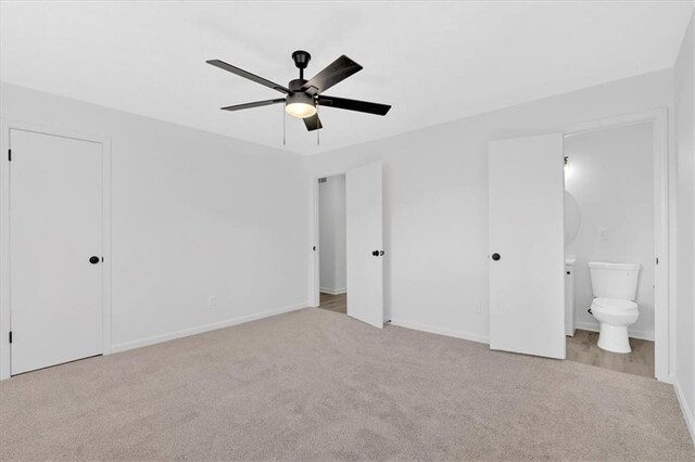 unfurnished bedroom featuring ceiling fan, baseboards, carpet floors, and ensuite bath