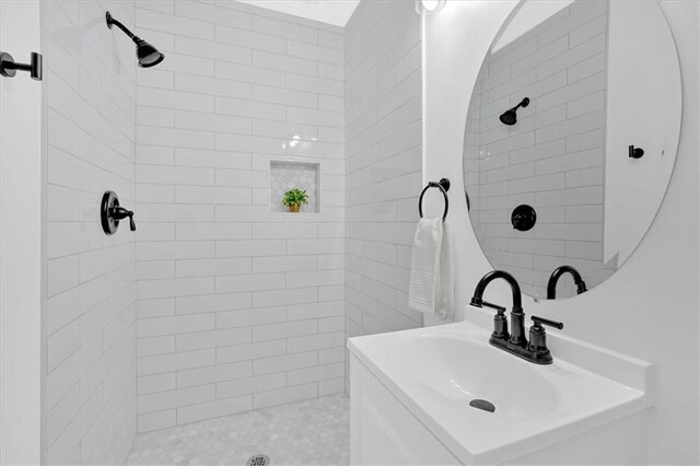 full bathroom with a tile shower and a sink