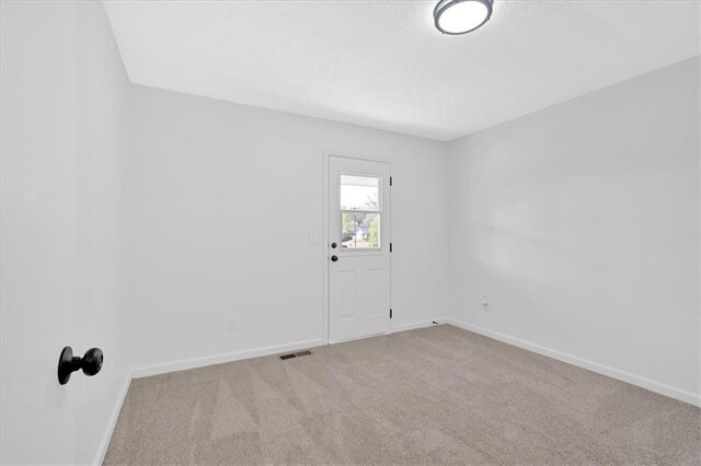 empty room featuring baseboards and carpet