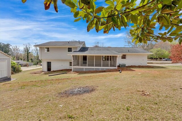 rear view of property with a lawn, brick siding, and a sunroom