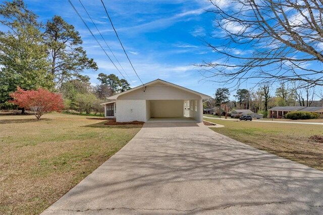 view of front of home with an attached carport, driveway, and a front lawn