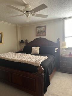 bedroom featuring light colored carpet, a textured ceiling, ceiling fan, and crown molding