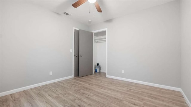 unfurnished bedroom with visible vents, ceiling fan, baseboards, wood finished floors, and a closet