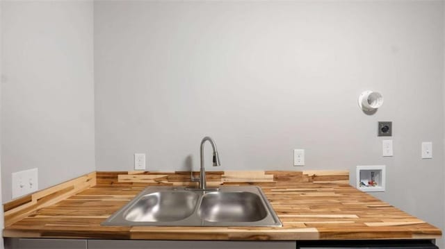 interior space with butcher block counters and a sink