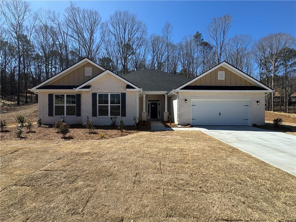 ranch-style home with a garage, concrete driveway, brick siding, and board and batten siding