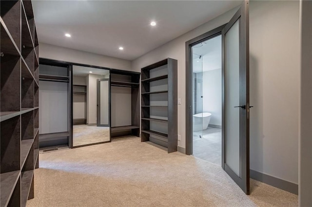 walk in closet featuring light carpet