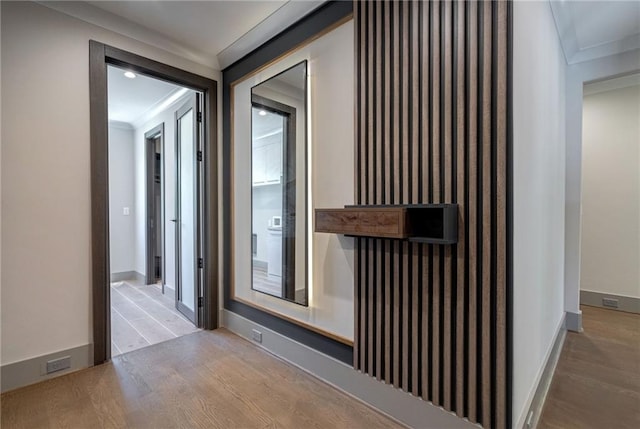 corridor with crown molding, baseboards, and wood finished floors