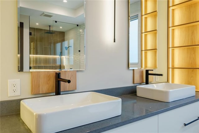 bathroom featuring double vanity, recessed lighting, a shower stall, and a sink