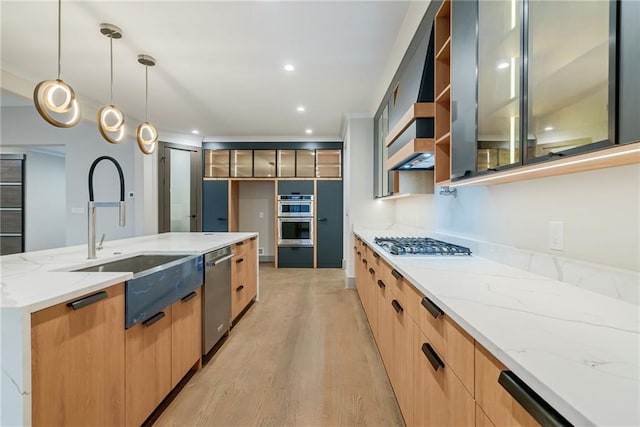kitchen featuring a sink, modern cabinets, light stone countertops, and stainless steel appliances