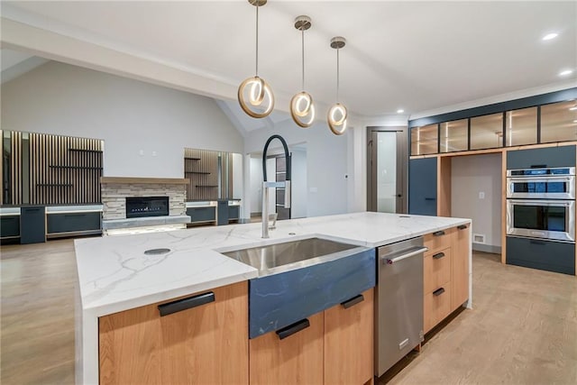 kitchen with lofted ceiling with beams, a sink, light wood-style floors, stainless steel appliances, and modern cabinets