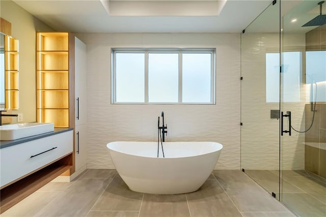 bathroom featuring vanity, a freestanding tub, and a stall shower