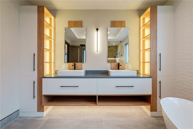 bathroom featuring a sink, a soaking tub, a stall shower, and double vanity