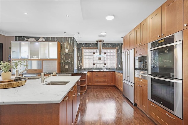 kitchen with crown molding, sink, built in appliances, dark hardwood / wood-style floors, and range hood