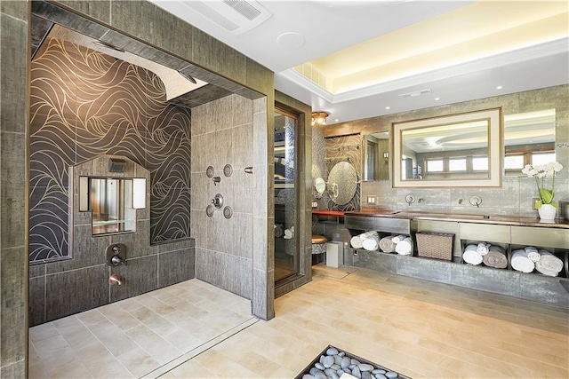 bathroom featuring tiled shower and vanity