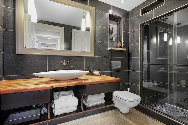 bathroom featuring an enclosed shower, vanity, toilet, and tile walls