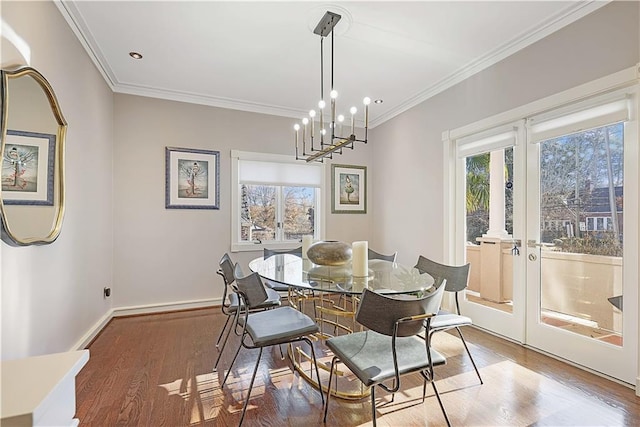 dining space featuring hardwood / wood-style floors, crown molding, and an inviting chandelier