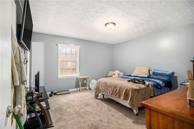 bedroom with carpet, baseboards, and a textured ceiling