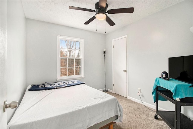 bedroom featuring a textured ceiling, ceiling fan, carpet, and baseboards