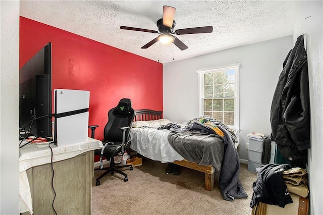 carpeted bedroom with a textured ceiling, ceiling fan, and baseboards