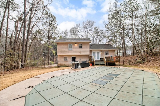 back of property featuring a patio, a fenced backyard, a chimney, a deck, and french doors