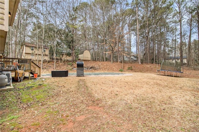 view of yard with a deck and a trampoline