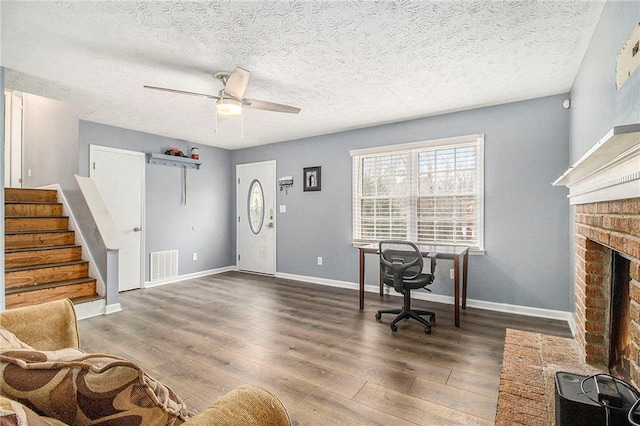 office area with visible vents, a fireplace, baseboards, and wood finished floors