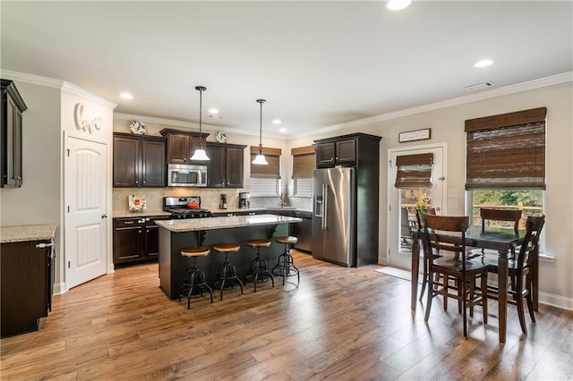 4305 Hunters Walk Way, Cumming, GA 30028 - kitchen with appliances with stainless steel finishes, a kitchen bar, dark brown cabinetry, healthy amount of natural light, and recessed lighting