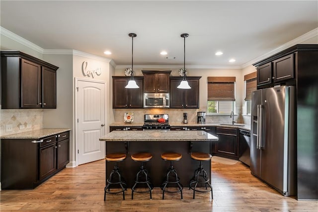 4305 Hunters Walk Way, Cumming, GA 30028 - kitchen with stainless steel appliances, a sink, dark brown cabinetry, light stone counters, and a breakfast bar