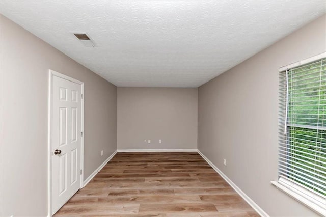 5290 Forest Downs Ln, Atlanta, GA 30349 - empty room with light wood-style floors, baseboards, and a textured ceiling