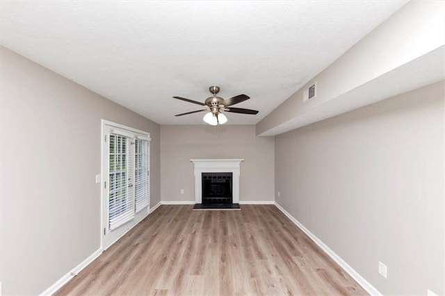 5290 Forest Downs Ln, Atlanta, GA 30349 - unfurnished living room featuring ceiling fan, light wood-style floors, a fireplace with raised hearth, and baseboards