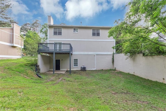 5290 Forest Downs Ln, Atlanta, GA 30349 - rear view of house with a wooden deck, a lawn, a chimney, and cooling unit