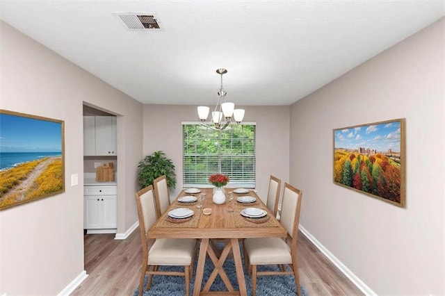 5290 Forest Downs Ln, Atlanta, GA 30349 - dining area with light wood-style flooring, a chandelier, baseboards, and a water view