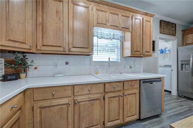 kitchen featuring tasteful backsplash, sink, stainless steel appliances, dark wood-type flooring, and crown molding