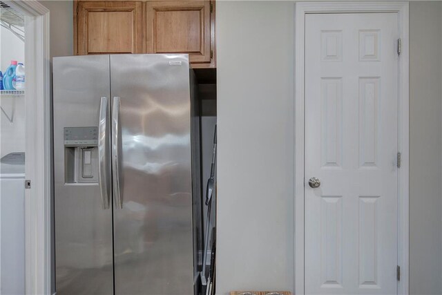 kitchen with washer / clothes dryer and stainless steel fridge with ice dispenser