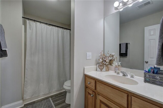 bathroom with vanity, hardwood / wood-style floors, a shower with curtain, and toilet