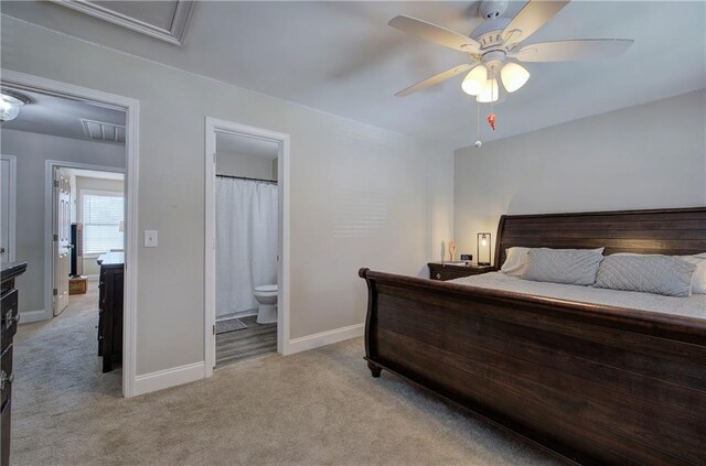 carpeted bedroom with ceiling fan and ensuite bath