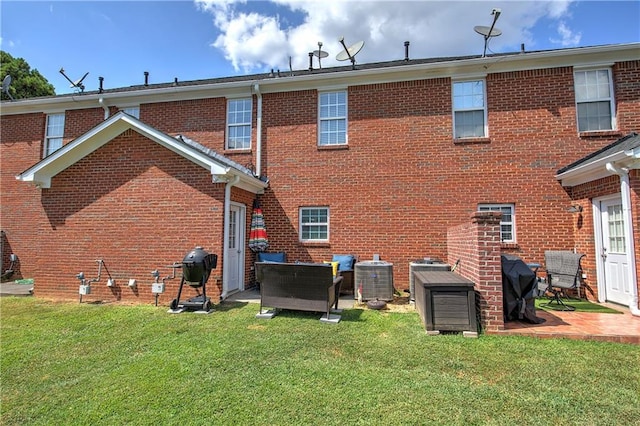 rear view of house with a yard, a patio area, and central AC