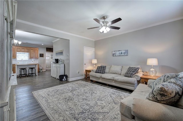 living room with dark wood-type flooring, ceiling fan, ornamental molding, and sink