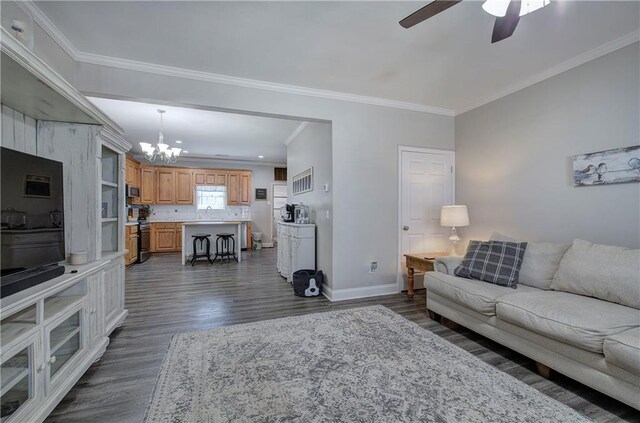 living room featuring crown molding, dark hardwood / wood-style flooring, and ceiling fan with notable chandelier