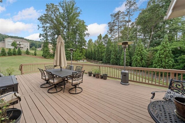 2385 Saddle Brook Trce, Cumming, GA 30040 - wooden deck featuring outdoor dining space, a lawn, and view of scattered trees