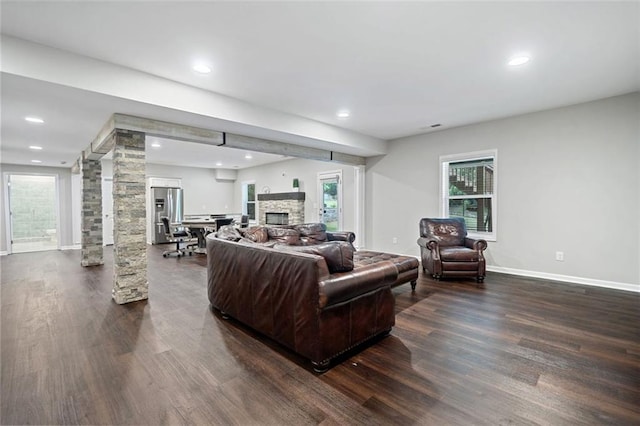 2385 Saddle Brook Trce, Cumming, GA 30040 - living room featuring dark wood-style flooring, a fireplace, decorative columns, recessed lighting, and baseboards